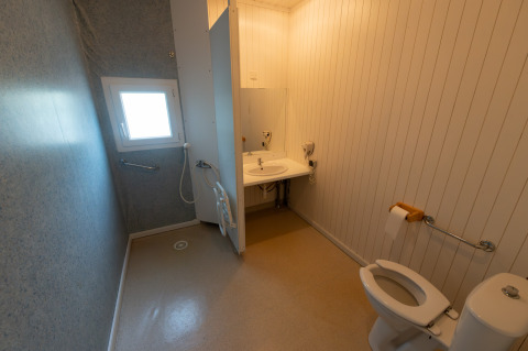 Toegankelijke badkamer in Chalet «l'O douce», Flower Camping la Pinède, Frankrijk, met beugels en open douche.