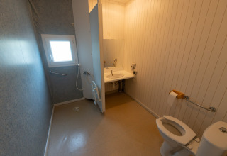 Toegankelijke badkamer in Chalet «l'O douce», Flower Camping la Pinède, Frankrijk, met beugels en open douche.