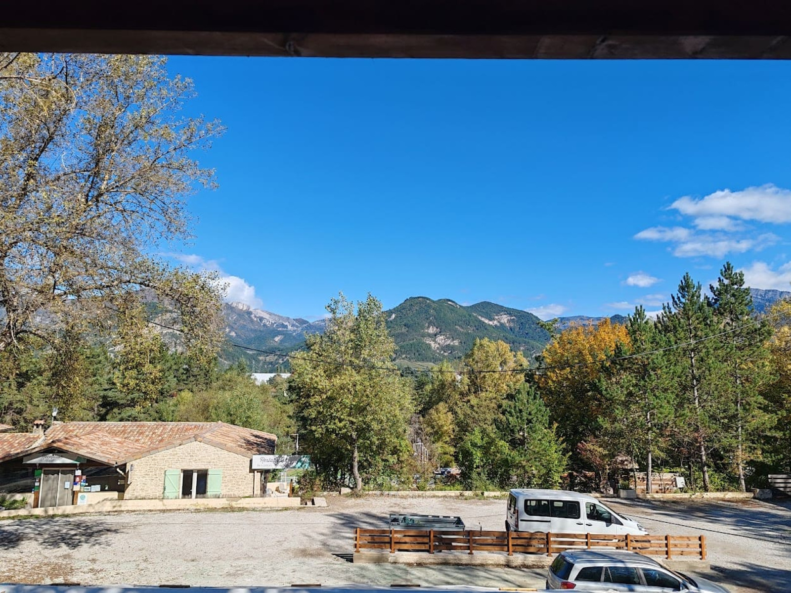 Uitzicht vanaf Chalet «Confort Vercors» bij Flower Camping la Pinède, Frankrijk, met bergen en blauwe lucht.