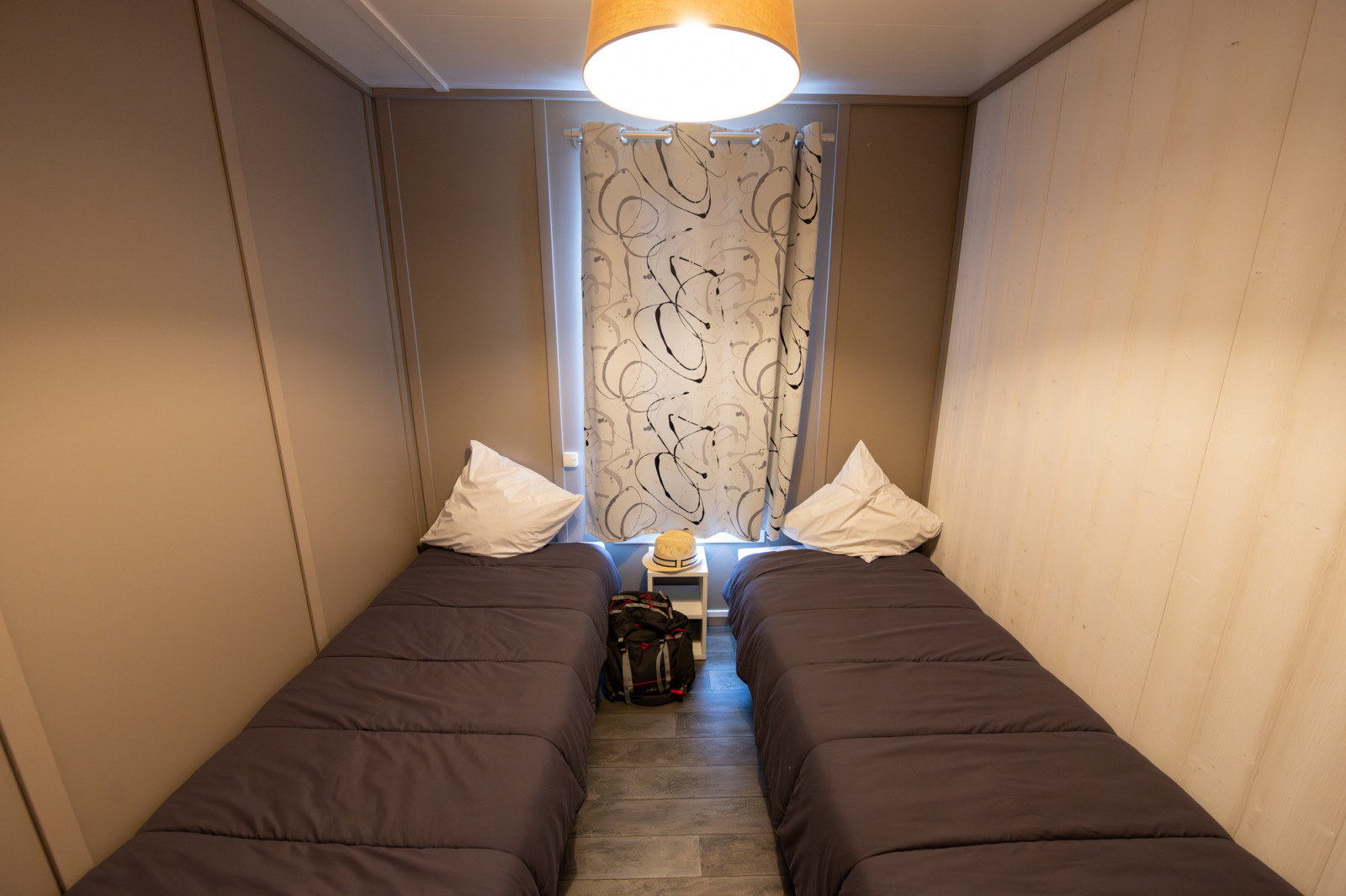 Slaapkamer met twee eenpersoonsbedden, grijs beddengoed en nachtkastje in Chalet «Confort Vercors» in Frankrijk.