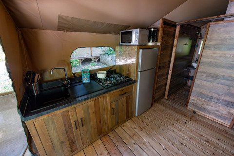 Keuken van safari tent Lodge «Insolite Pinède 34 m²» bij Flower Camping la Pinède in Frankrijk, volledig ingericht.