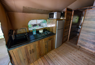 Keuken van safari tent Lodge «Insolite Pinède 34 m²» bij Flower Camping la Pinède in Frankrijk, volledig ingericht.