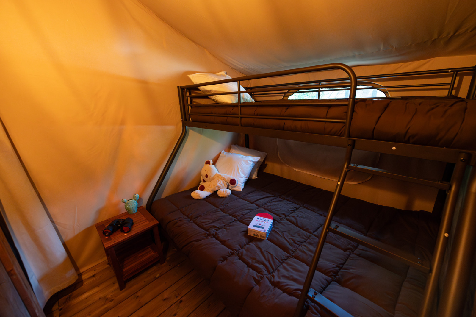 Binnenaanzicht van safaritent Lodge Insolite Pinède bij Flower Camping la Pinède met stapelbedden en speelgoed.