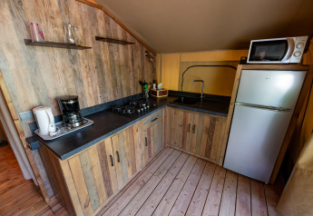 Køkkenområde i Lodge «Insolite Pinède 46m²» med træskabe, komfur, vask, kaffemaskine og køleskab.