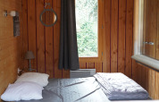 Wood-paneled bedroom in Chalet suitable for limited mobility at Family's Camping Le Savoy in France.
