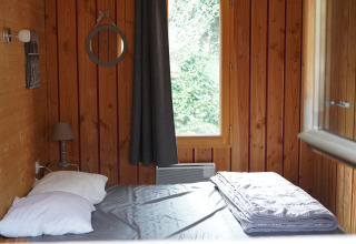 Wood-paneled bedroom in Chalet suitable for limited mobility at Family's Camping Le Savoy in France.