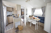 Cocina y comedor modernos en una casa móvil en Camping Paradis Family des Issoux, en Francia.