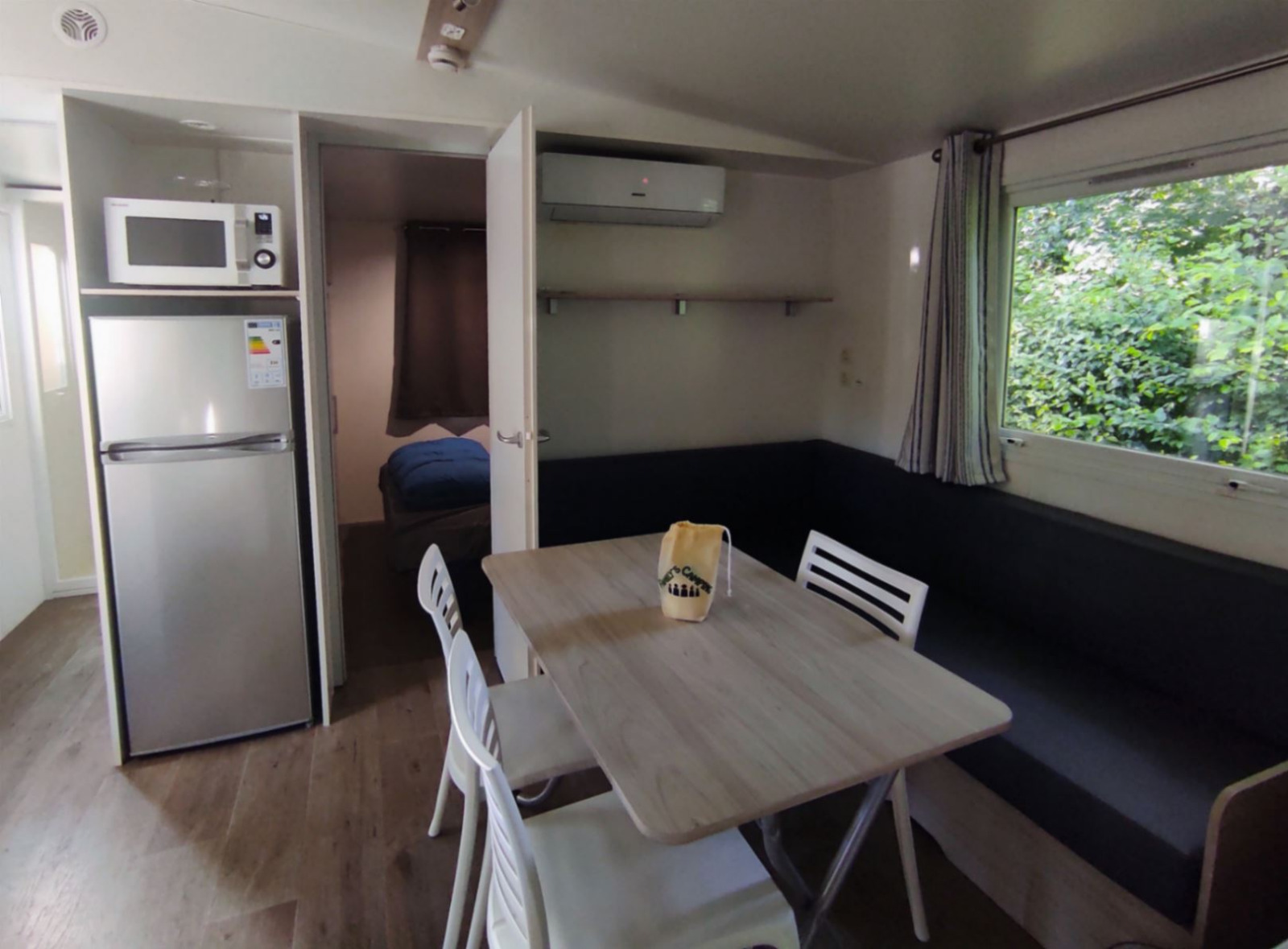 Woonruimte in Stacaravan CONFORT 30m² bij Family's Camping Le Savoy met eethoek en keuken.