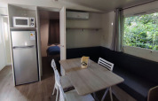Woonruimte in Stacaravan CONFORT 30m² bij Family's Camping Le Savoy met eethoek en keuken.