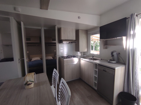 Keuken en eethoek in de Stacaravan CONFORT 30m² bij Family's Camping Le Savoy met zicht op slaapkamer.