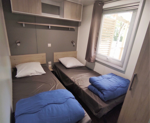 Twee enkele bedden in een lichte kamer van Stacaravan CONFORT 30m², Family's Camping Le Savoy, Frankrijk.