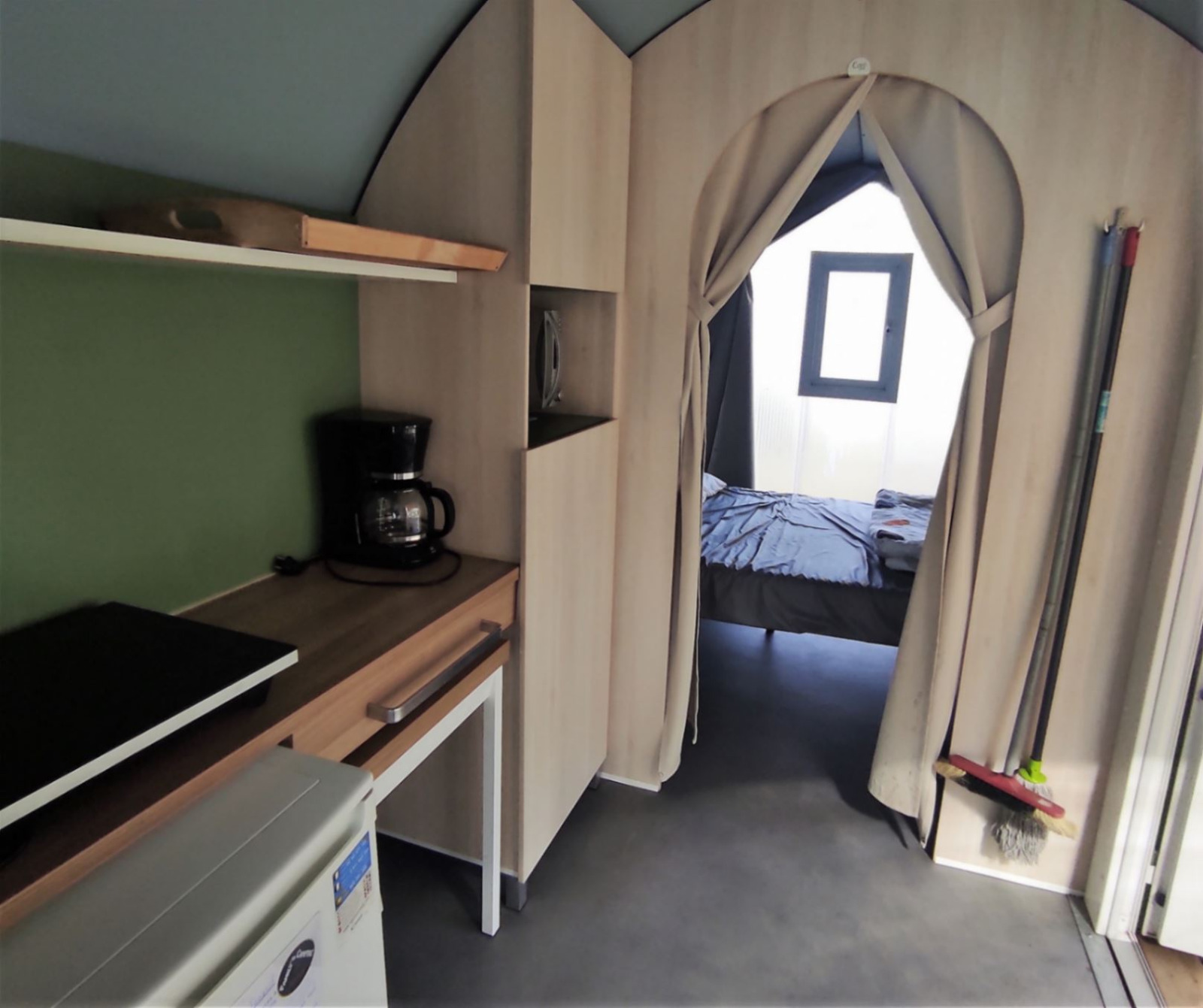 Binnenaanzicht van Coco Sweet safaritent met kitchenette en slaapkamer in Family's Camping Le Savoy in Frankrijk.
