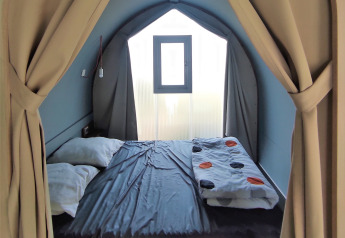 Vista interior de una tienda safari Coco Sweet con cama doble y ventana en Family's Camping Le Savoy.