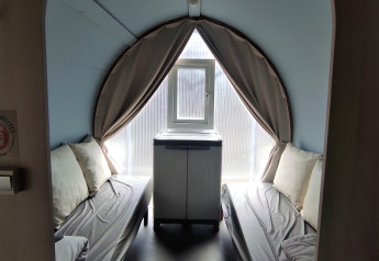 Interior de una tienda safari Coco Sweet con dos camas, almohadas y armario, Camping Le Savoy, Francia.