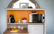 Kitchenette compacta en la tienda safari Coco Sweet del Flower Camping Provence Vallée con mesa y nevera.