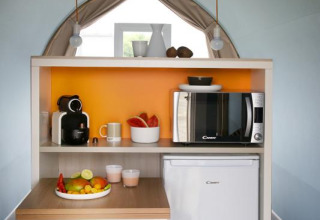 Angolo cottura compatto nella tenda safari Coco Sweet al Flower Camping Provence Vallée con tavolo e frigo.