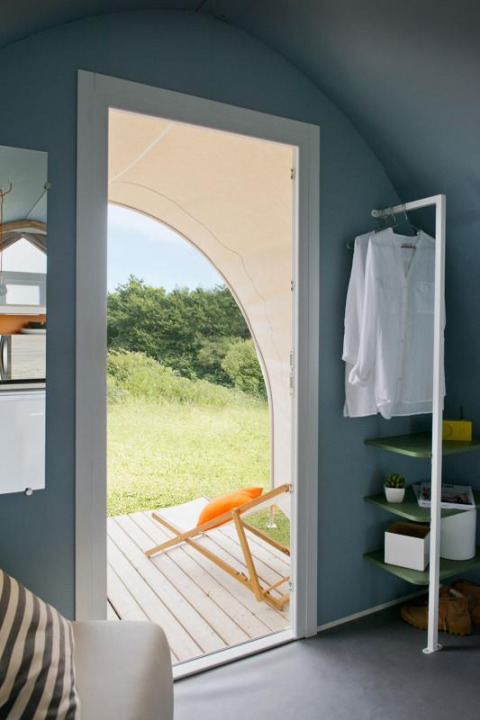 Interno della tenda Coco Sweet con porta aperta, sdraio sulla terrazza e vista verde a Provence Vallée, Francia.