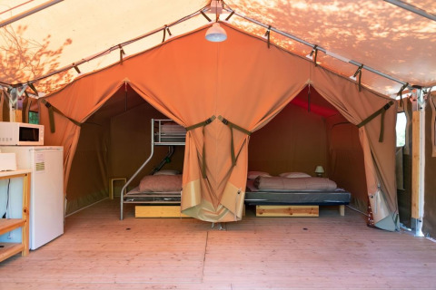 Innenansicht eines Freeflower Safari-Zeltes mit Betten, Kühlschrank und Mikrowelle in Flower Camping Provence Vallée.