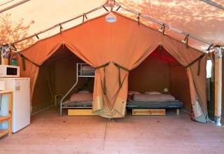 Innenansicht eines Freeflower Safari-Zeltes mit Betten, Kühlschrank und Mikrowelle in Flower Camping Provence Vallée.
