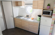Cuisine lumineuse du Mobile Home «ECO Lodgia» au Flower Camping Provence Vallée, avec cuisinière et équipements modernes.