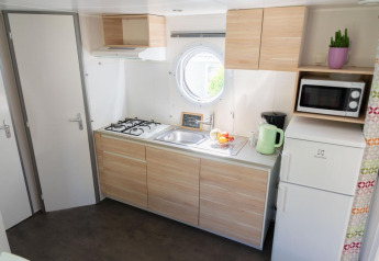 Lyst køkken i Mobile Home «ECO Lodgia» på Flower Camping Provence Vallée, med komfur og moderne faciliteter.