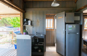 Innenaufnahme einer Baumhausküche mit Kühlschrank, Spüle und Kaffeemaschine im Flower Camping Provence Vallée.