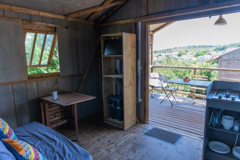 Indendørs udsigt fra Lodgehut op palen på Flower Camping Provence Vallée, Frankrig, med terrasse.