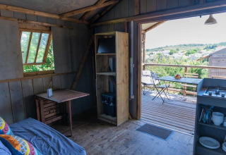 Indendørs udsigt fra Lodgehut op palen på Flower Camping Provence Vallée, Frankrig, med terrasse.