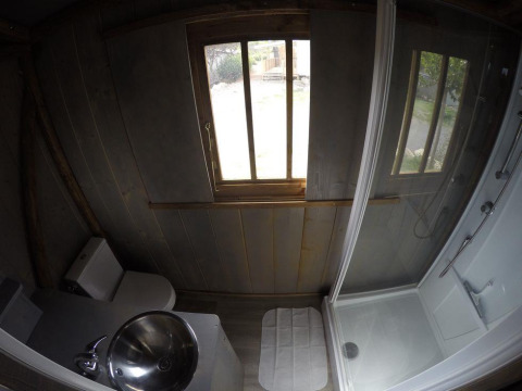 Badezimmer in einem Baumhaus mit WC, Waschbecken und Dusche in Lodgehut op palen bei Flower Camping Provence Vallée.