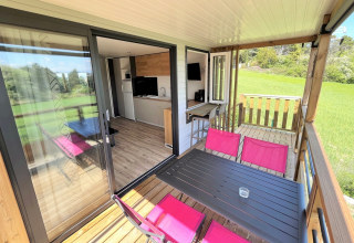 Mobilhome Living ved Flower Camping Provence Vallée med terrasse, bord og udsigt til grønt område.
