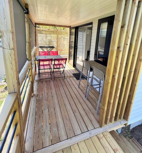 Überdachte Holzterrasse mit Essbereich im Mobile Home „Living“ bei Flower Camping Provence Vallée, Frankreich.