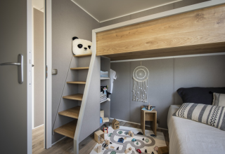 Modern kids' room in a Mobile Home Living at Flower Camping Provence Vallée with loft bed and play mat.