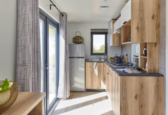 Moderne keuken met houten kasten en grote ramen in Mobile Home «New Horizon» bij Flower Camping Provence Vallée.