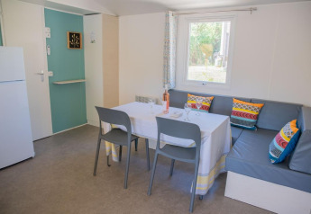 Spisestue i Mobile Home «Tribu» på Flower Camping Provence Vallée i Frankrig med hjørnesofa og farverige puder.