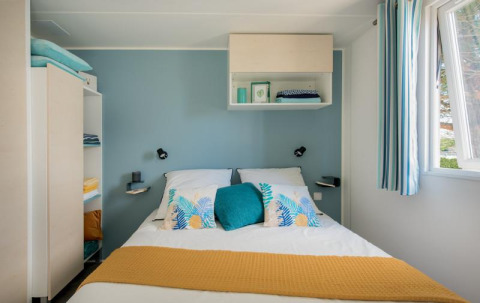 Schlafzimmer im Mobile Home «Tribu» auf dem Flower Camping Provence Vallée in Frankreich mit blau-weißem Dekor.