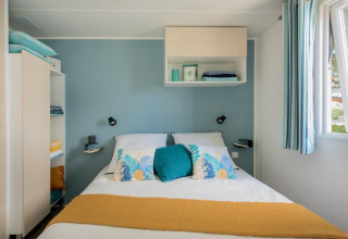 Dormitorio en Mobile Home «Tribu» en Flower Camping Provence Vallée, Francia, con decoración azul y blanca.