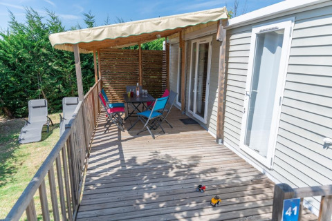 Terrasse mit Sitzbereich, Spielzeugautos und Liegestühlen am Premium Mobile Home in Flower Camping Provence Vallée.