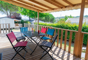 Overdækket træterrasse med farverige stole og bord ved Premium Mobile Home på Flower Camping Provence Vallée.