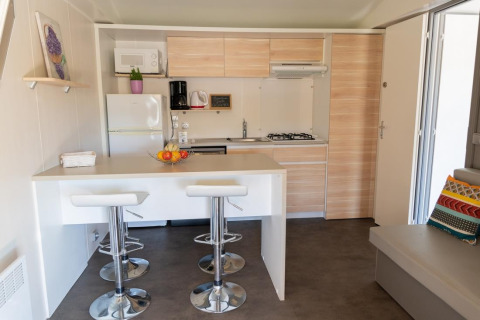 Modern kitchen interior of Premium Mobile Home with breakfast bar at Flower Camping Provence Vallée in France.