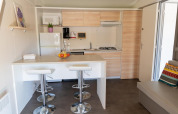 Moderne Küchenzeile mit Tresen und Hockern im Premium Mobile Home bei Flower Camping Provence Vallée in Frankreich.