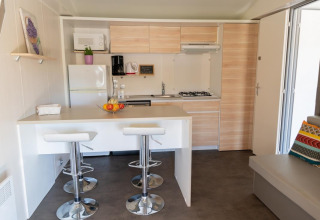 Modern kitchen interior of Premium Mobile Home with breakfast bar at Flower Camping Provence Vallée in France.