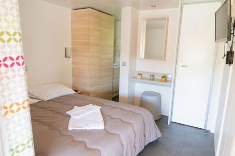 Premium Mobile Home med 2 soveværelser på Flower Camping Provence Vallée, lyst værelse med seng og tv.