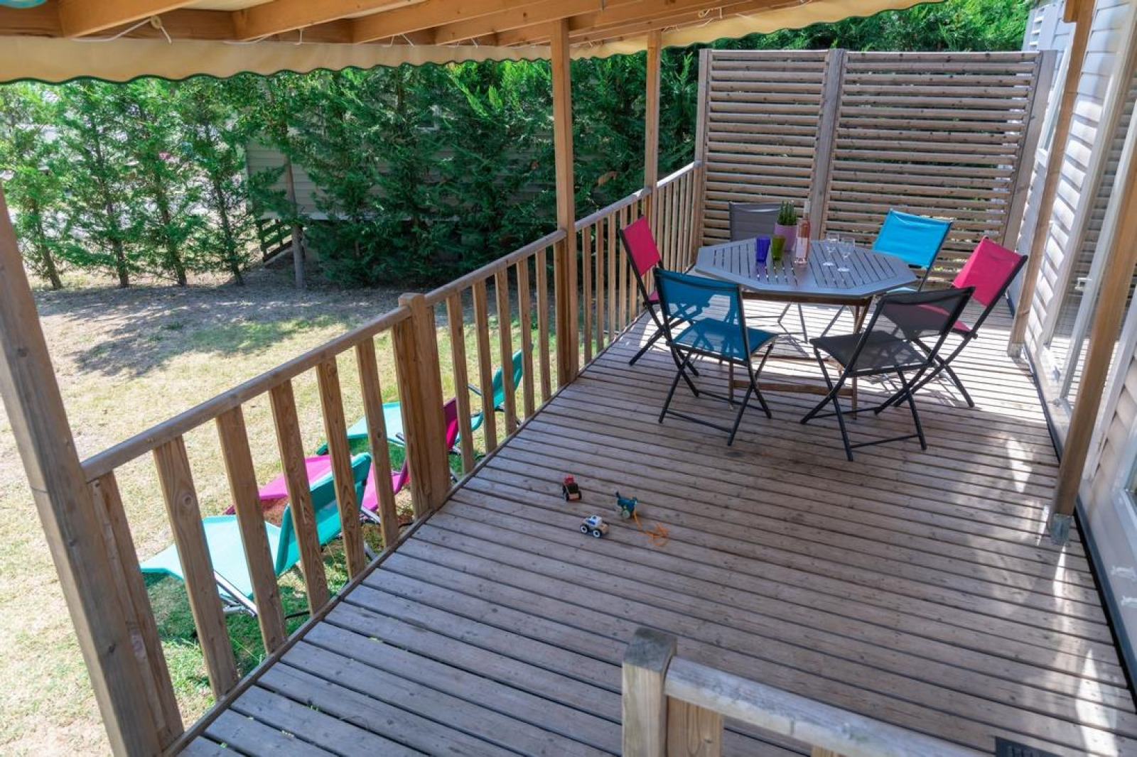 Houten veranda met kleurrijke stoelen bij Premium Mobile Home op Flower Camping Provence Vallée in Frankrijk.