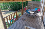 Holzterrasse mit bunten Stühlen und Tisch im Premium Mobile Home bei Flower Camping Provence Vallée, Frankreich.