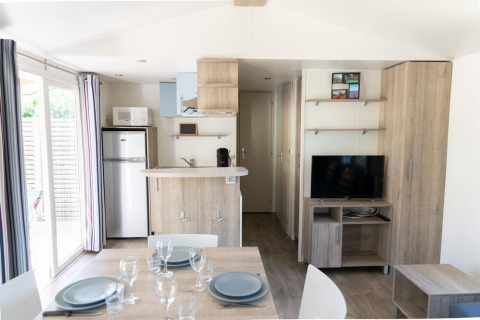 Helles Premium Mobilheim mit Küche, Esstisch und TV im Flower Camping Provence Vallée in Frankreich.
