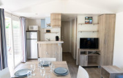 Helles Premium Mobilheim mit Küche, Esstisch und TV im Flower Camping Provence Vallée in Frankreich.