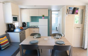 Indvendigt billede af Premium Mobile Home med fuldt udstyret køkken og spiseplads hos Provence Vallée.