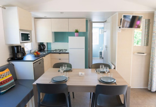 Intérieur d’un Premium Mobile Home avec cuisine équipée et coin repas chez Provence Vallée, France.
