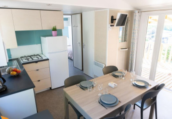 Cucina e sala da pranzo moderne nella Premium Mobile Home al Flower Camping Provence Vallée, apparecchiata per quattro.