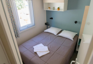Dormitorio en una Premium Mobile Home con cama doble, ventana y decoración moderna en Flower Camping Provence Vallée.